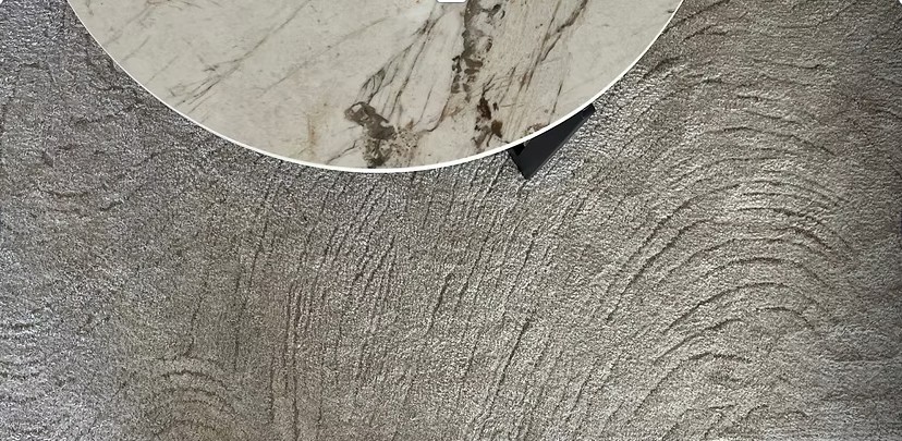 Close-up of the marble coffee table's veining against a textured stone wall