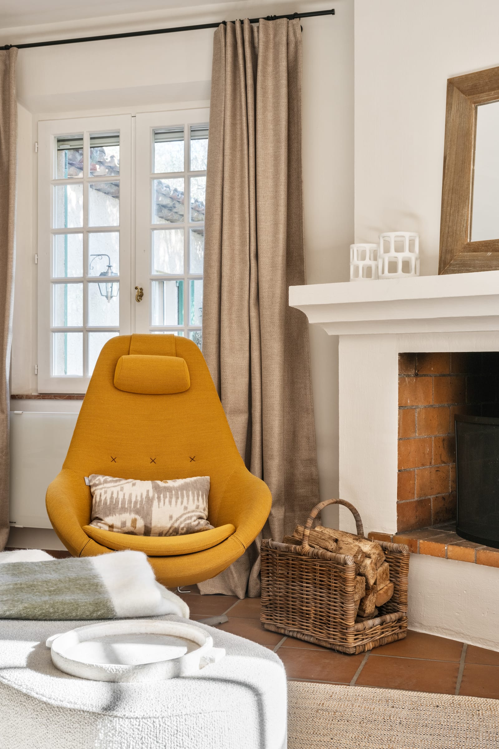 Earthy living room with a beige sofa, black stone coffee table, jute rug, and a framed Picasso print