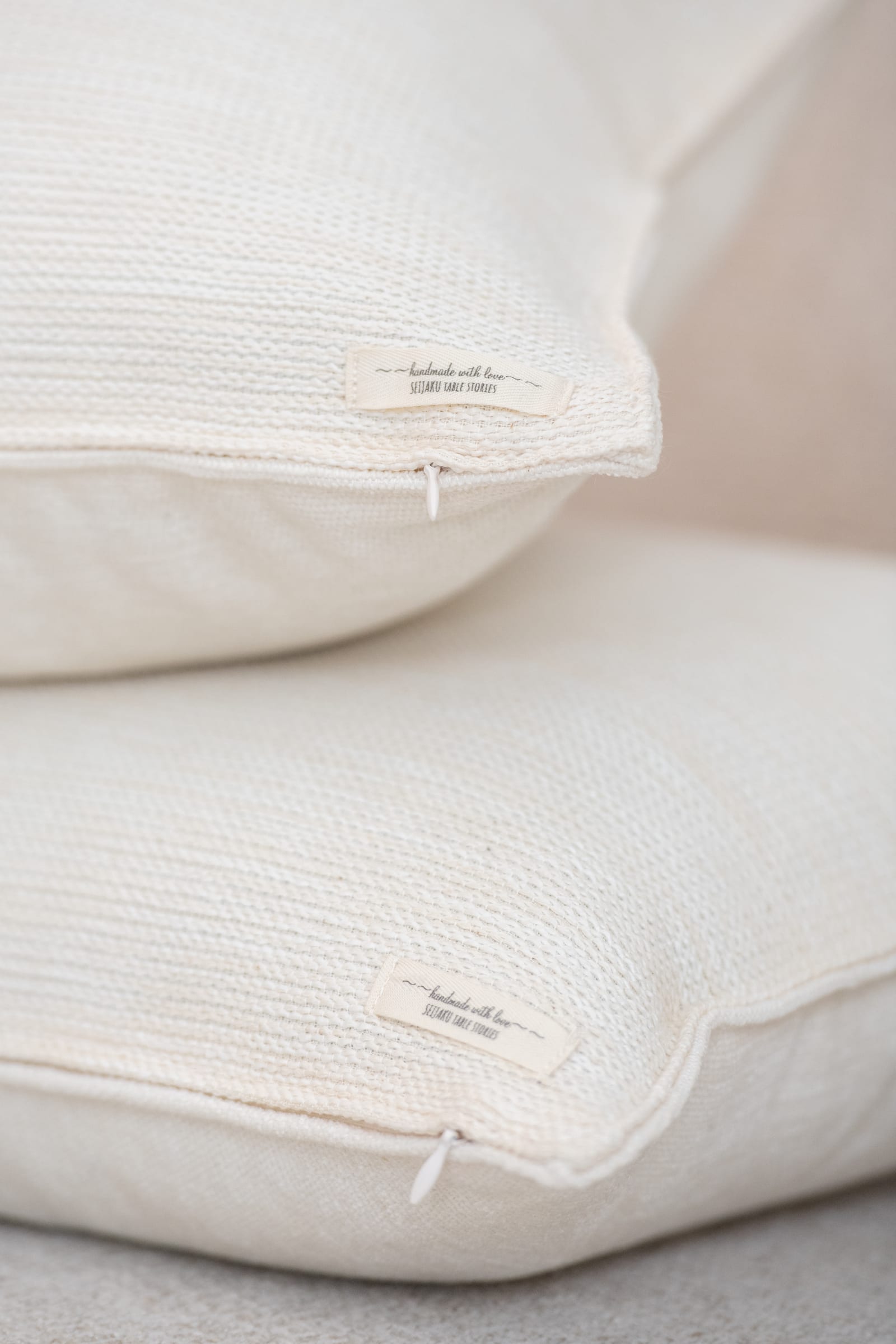 Off-white, softly textured SEIJAKU limited-edition cushion